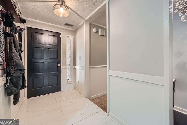 entrance foyer with a textured ceiling and crown molding