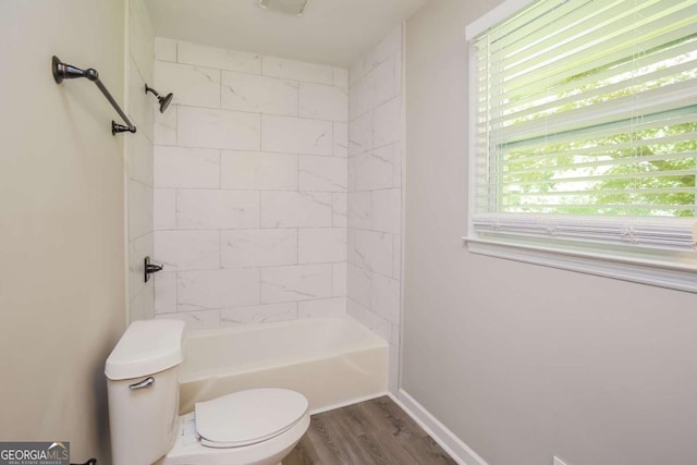 bathroom featuring hardwood / wood-style flooring, toilet, and tiled shower / bath