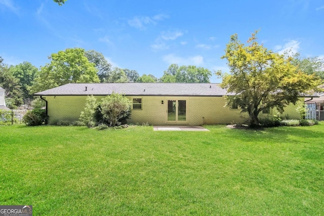 rear view of house featuring a lawn and a patio area