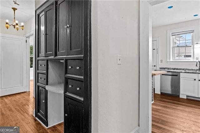 kitchen featuring dishwasher, white cabinets, a kitchen breakfast bar, sink, and butcher block counters