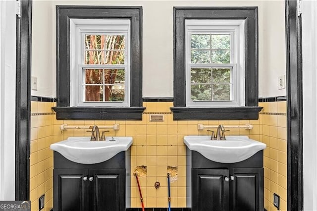 kitchen with light stone countertops, stainless steel dishwasher, sink, white cabinets, and dark hardwood / wood-style floors