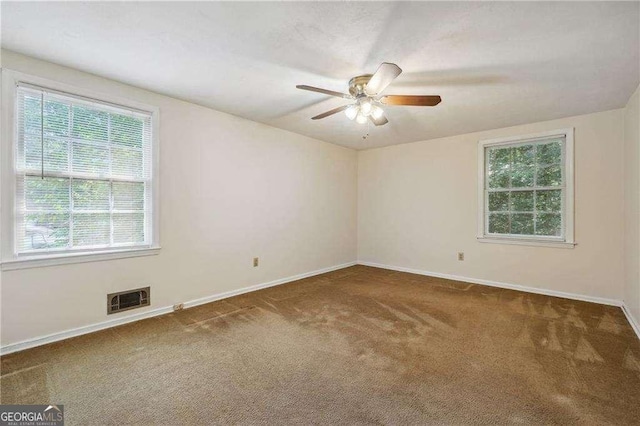 carpeted spare room with ceiling fan and a wealth of natural light