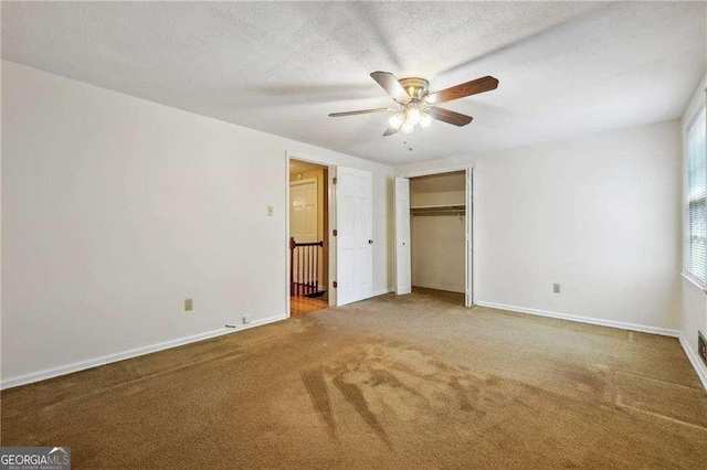 unfurnished bedroom with ceiling fan, carpet floors, a textured ceiling, and a closet