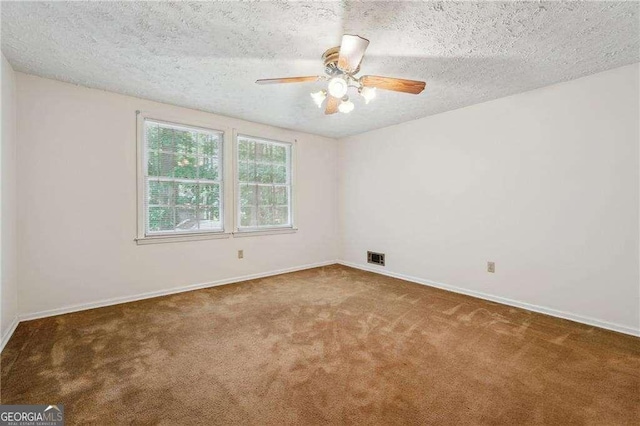 carpeted spare room featuring ceiling fan and a textured ceiling