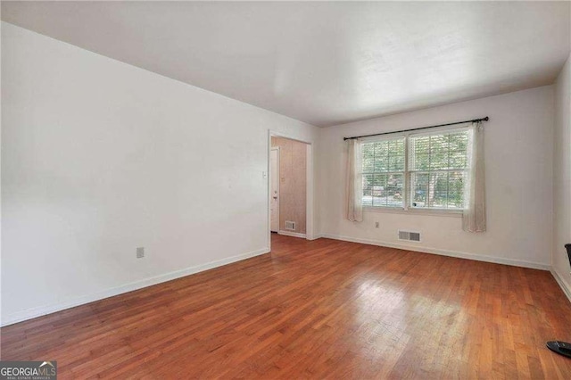 unfurnished room with hardwood / wood-style flooring