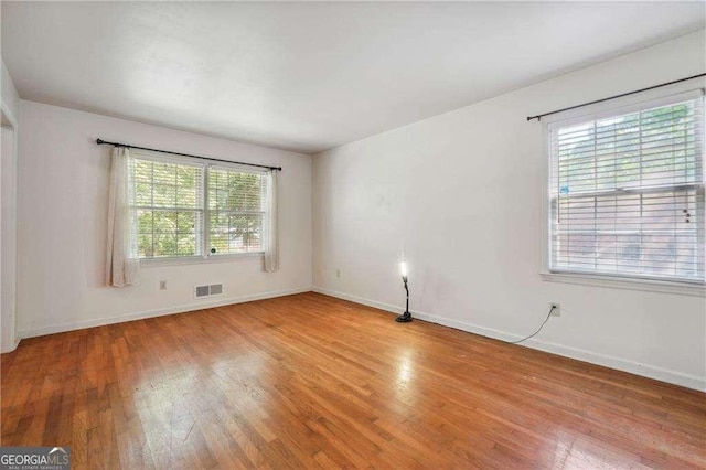 spare room featuring light hardwood / wood-style flooring and a wealth of natural light