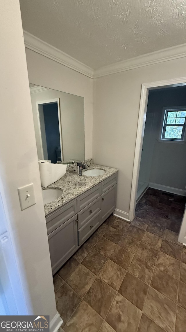 bathroom featuring vanity, a textured ceiling, and ornamental molding