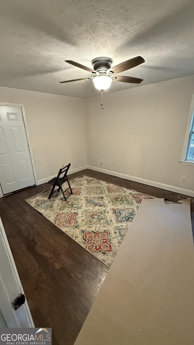 empty room with a textured ceiling, ceiling fan, and dark wood-type flooring