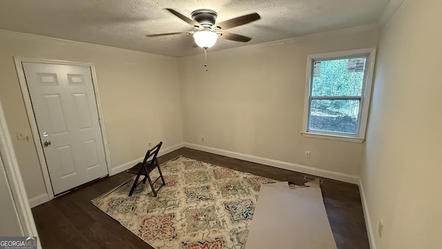 office area featuring ceiling fan, dark wood-type flooring, a textured ceiling, and ornamental molding