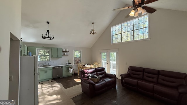 living room with french doors, sink, dark hardwood / wood-style flooring, high vaulted ceiling, and ceiling fan with notable chandelier