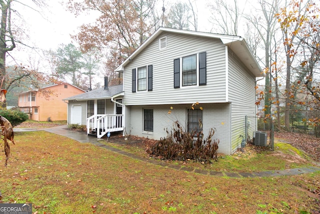 view of front of home featuring a front yard and central AC