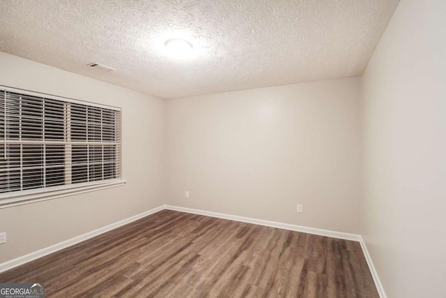 unfurnished room featuring a textured ceiling and hardwood / wood-style flooring