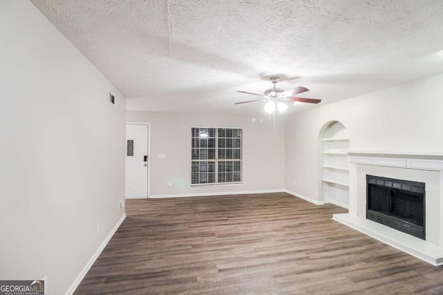 unfurnished living room featuring ceiling fan, wood-type flooring, and a textured ceiling