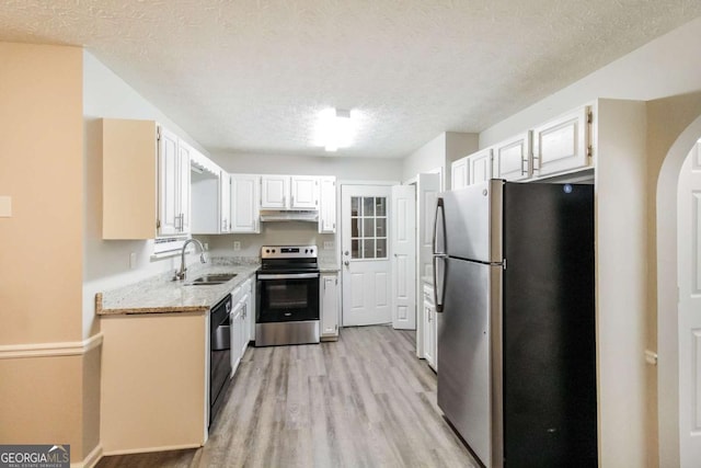 kitchen with appliances with stainless steel finishes, a textured ceiling, sink, light hardwood / wood-style flooring, and white cabinetry