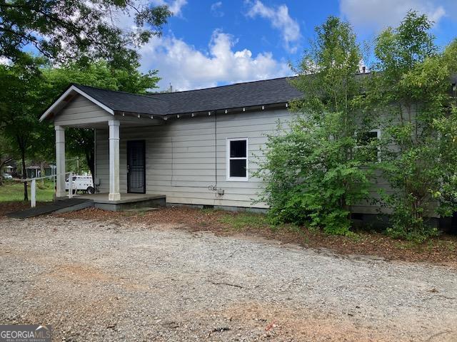 rear view of house featuring covered porch