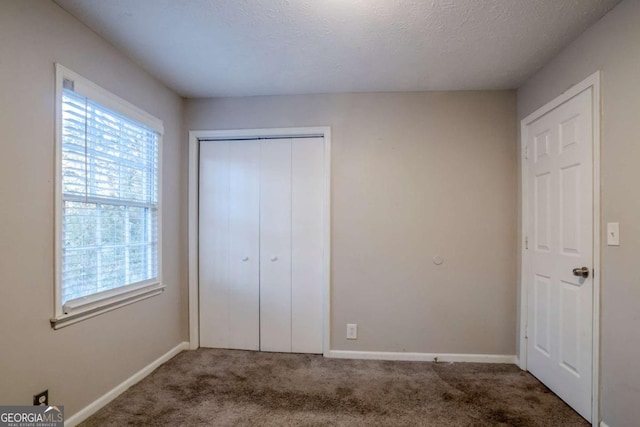 unfurnished bedroom featuring a closet, carpet, and a textured ceiling