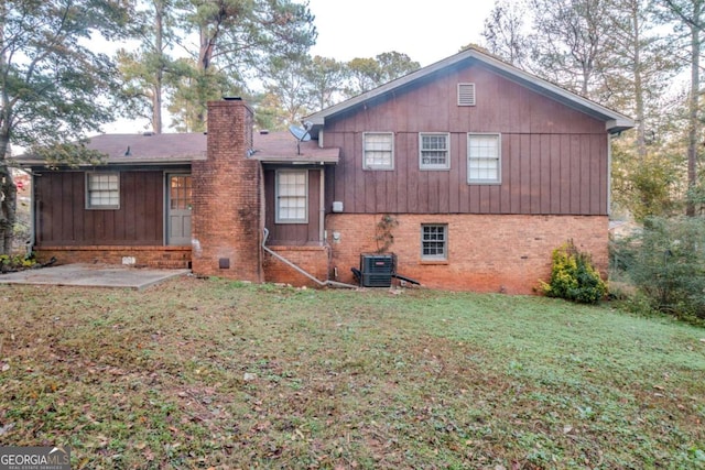 rear view of property with central air condition unit, a patio area, and a lawn