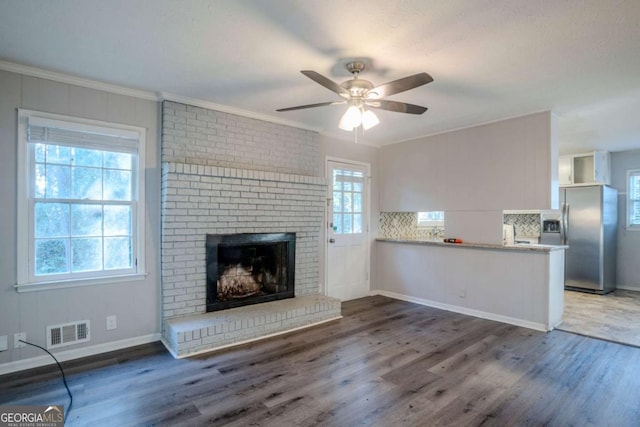 unfurnished living room with dark hardwood / wood-style floors, plenty of natural light, and ornamental molding