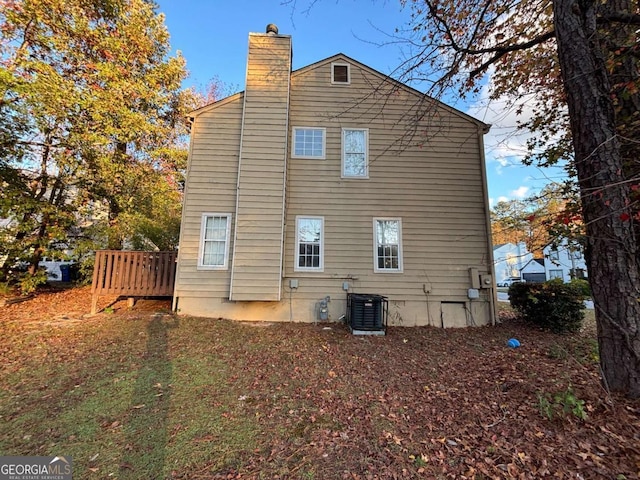 back of house featuring central AC unit and a wooden deck