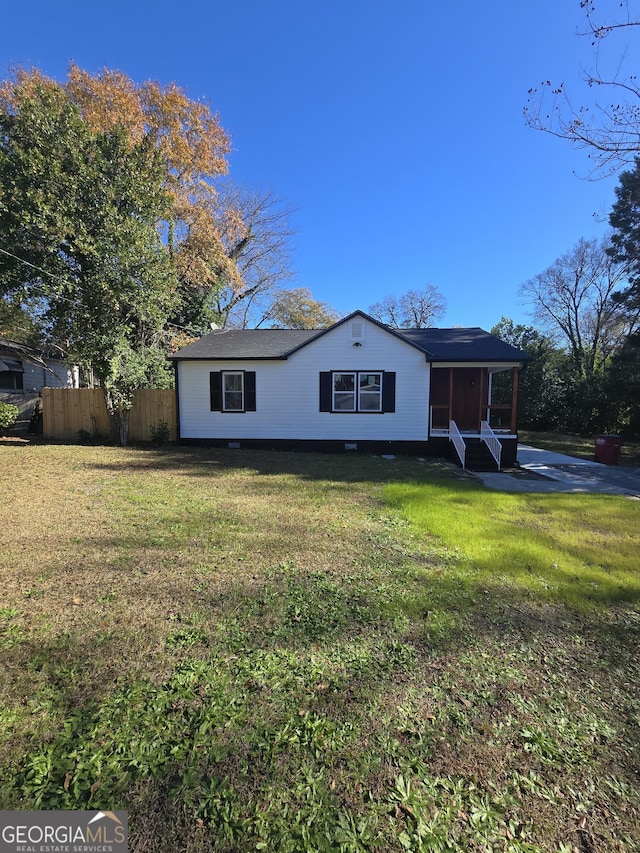 view of front of house with a sunroom and a front yard