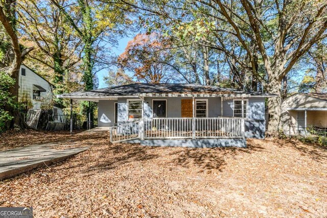 ranch-style house with covered porch and a carport