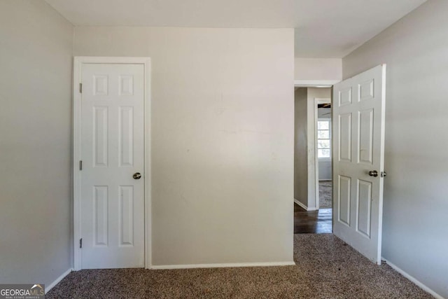 unfurnished room with dark colored carpet