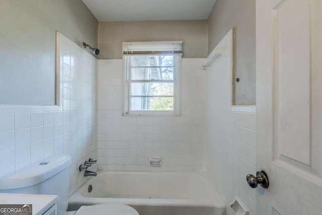 full bathroom with vanity, tiled shower / bath combo, toilet, and tile walls