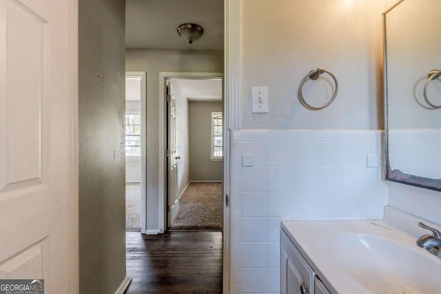 bathroom featuring hardwood / wood-style floors, vanity, and tile walls