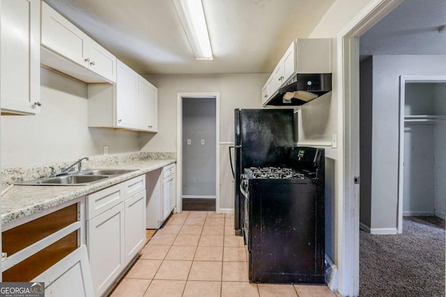 kitchen with gas stove, light tile patterned flooring, white cabinetry, and sink