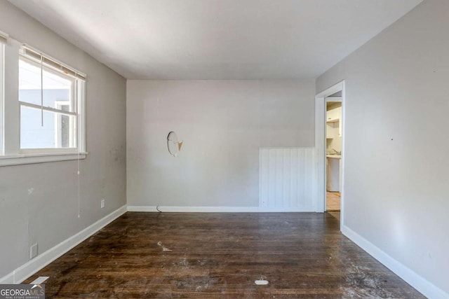 unfurnished room with dark wood-type flooring