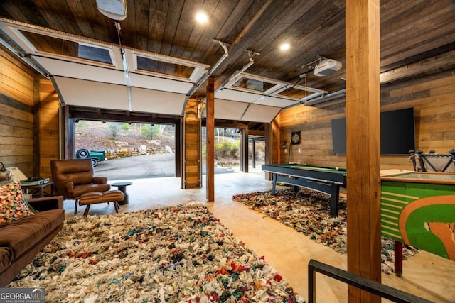 interior space featuring a garage door opener, wooden ceiling, and wood walls