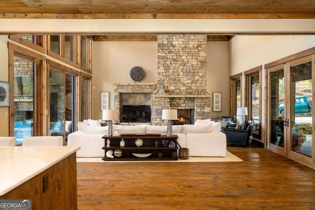 living room with french doors, dark hardwood / wood-style floors, and a stone fireplace