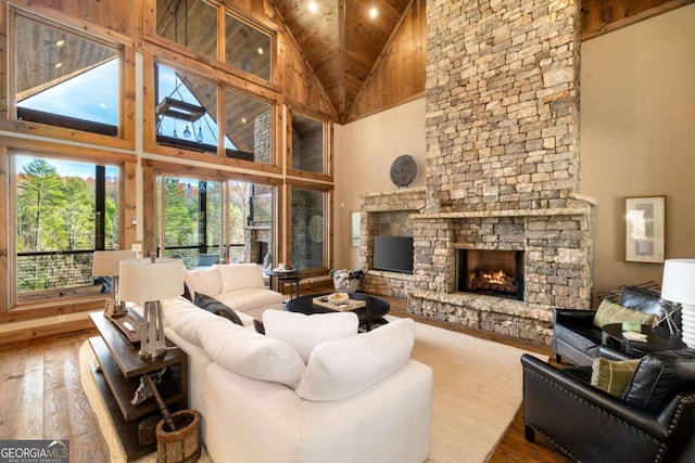 living room featuring a fireplace, wood-type flooring, high vaulted ceiling, and wood ceiling