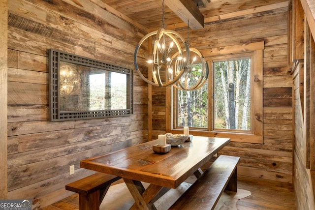 unfurnished dining area with beam ceiling, a chandelier, wood-type flooring, wooden walls, and wood ceiling