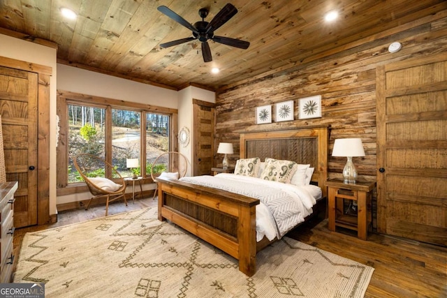 bedroom with wood-type flooring, ceiling fan, wooden walls, and wood ceiling