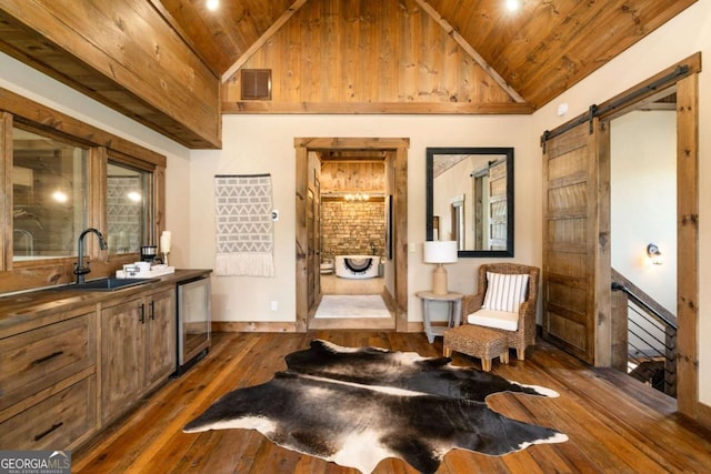 sitting room featuring a barn door, sink, wood ceiling, and dark wood-type flooring