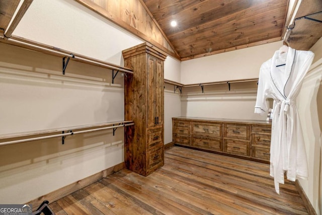 spacious closet with dark hardwood / wood-style floors and lofted ceiling