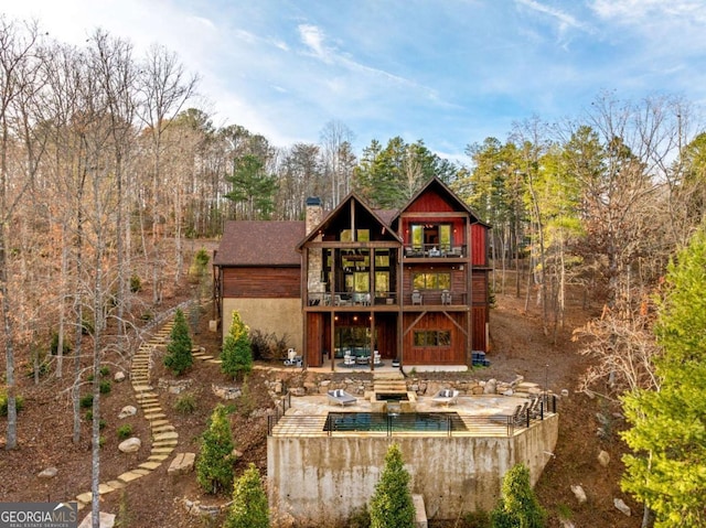 back of property with a pool side deck and a patio