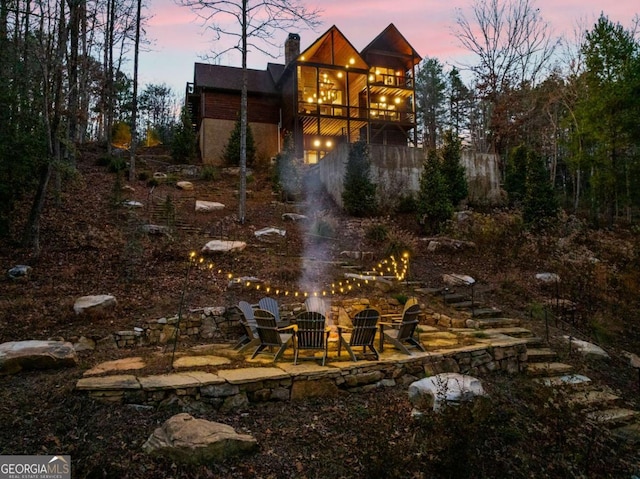 yard at dusk with a balcony and a patio