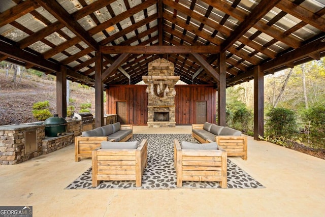 view of patio / terrace with an outdoor living space with a fireplace, a gazebo, an outdoor kitchen, and grilling area