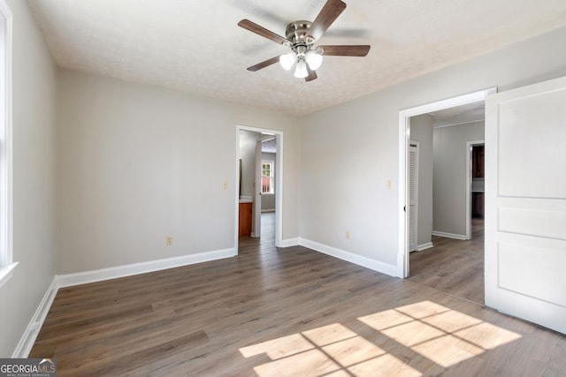 unfurnished bedroom with ceiling fan, wood-type flooring, and a textured ceiling