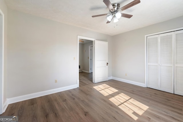 unfurnished bedroom with a textured ceiling, a closet, light hardwood / wood-style floors, and ceiling fan