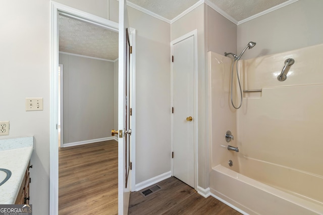 bathroom with shower / bathing tub combination, vanity, a textured ceiling, and hardwood / wood-style flooring