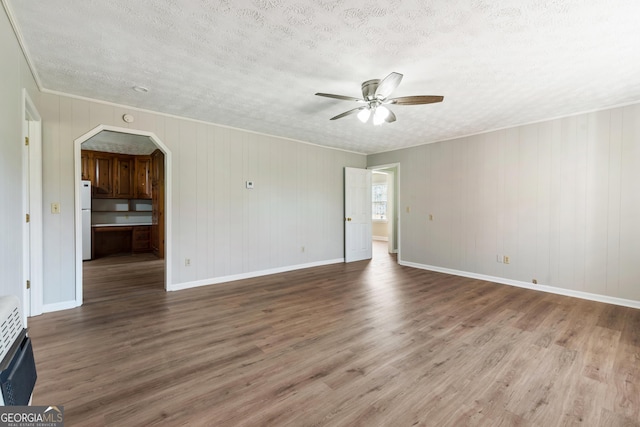 spare room featuring ceiling fan, wood-type flooring, a textured ceiling, and heating unit