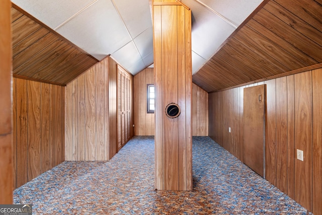 bonus room with carpet, wood walls, and vaulted ceiling