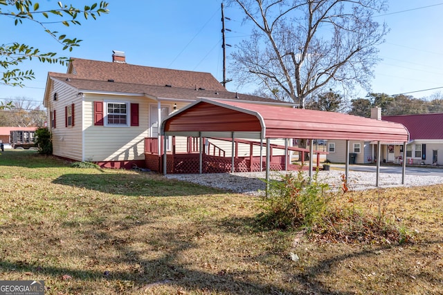 back of house with a carport and a lawn