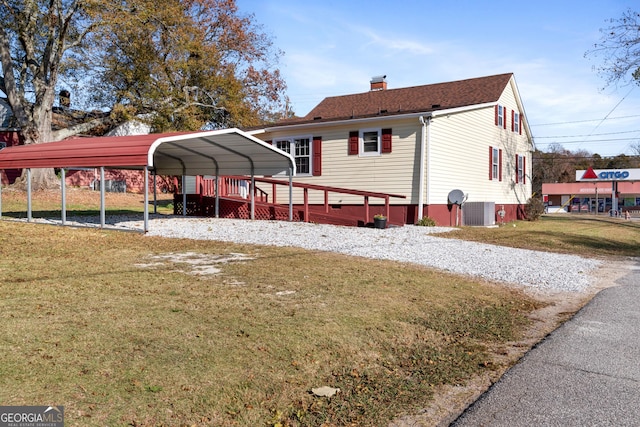 view of front of home featuring central air condition unit, a front yard, and a carport