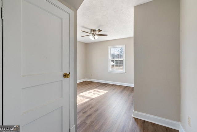 spare room featuring hardwood / wood-style flooring, ceiling fan, and a textured ceiling