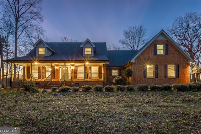 view of front of property with crawl space, brick siding, and covered porch