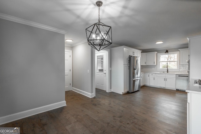 kitchen featuring white cabinetry, sink, tasteful backsplash, decorative light fixtures, and appliances with stainless steel finishes